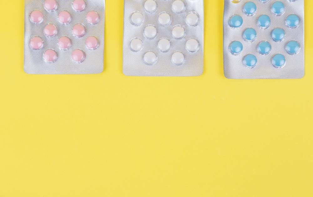 3 pill packets against a yellow background - probiotics after antibiotics. 