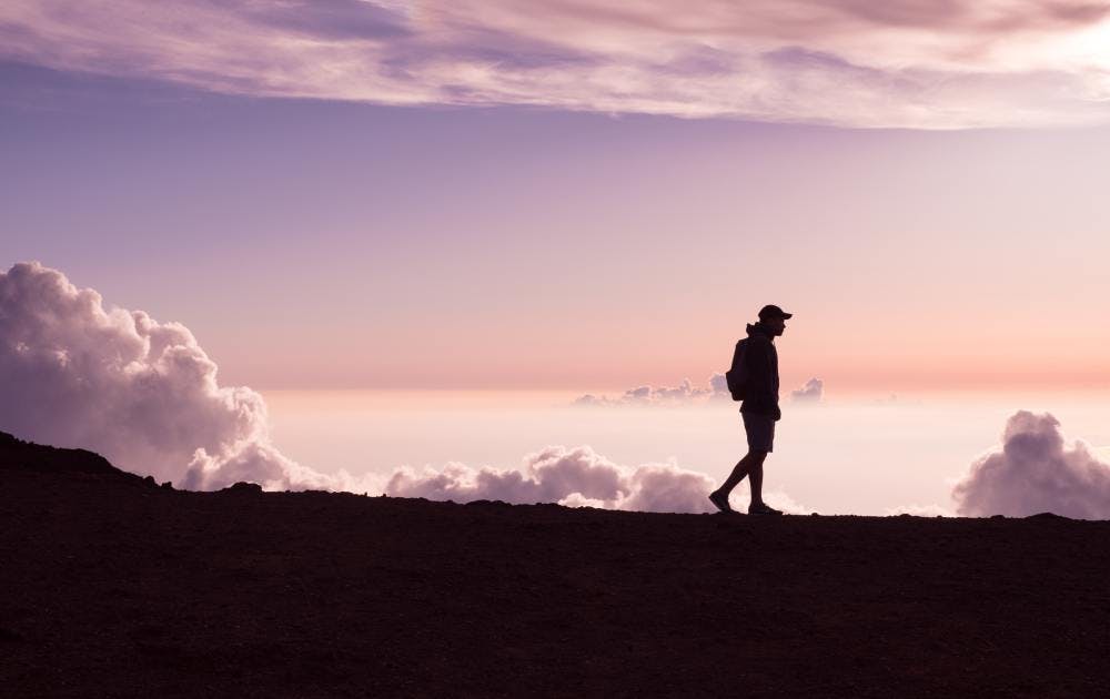 Man walking in front of clouds